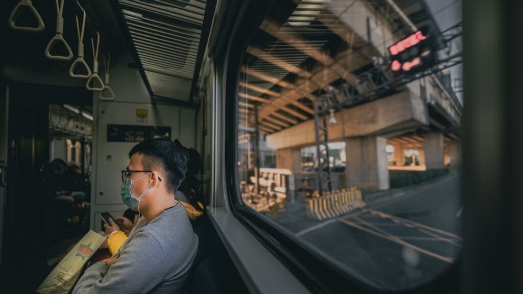 Person wearing over‑ear headphones while commuting on a train