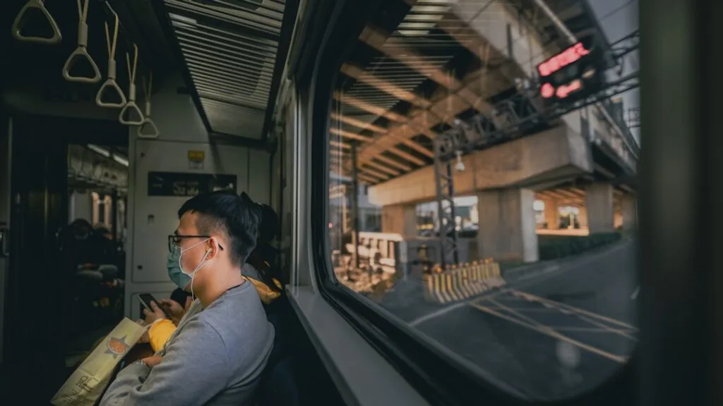 Person wearing over‑ear headphones while commuting on a train