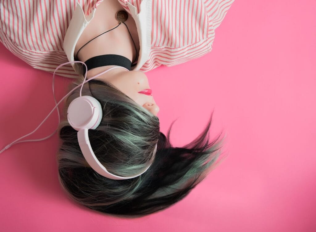 Person wearing over‑ear headphones while working on a laptop