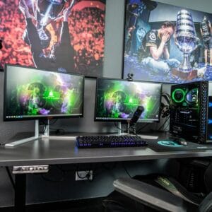 A gamer focused on a high‑performance laptop in a dimly lit gaming setup