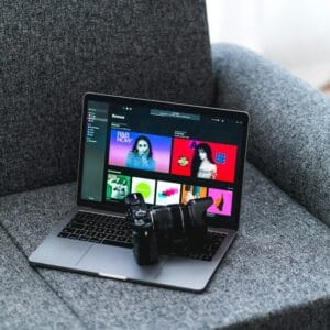 A person gaming on a sleek laptop in a cozy room with ambient lighting