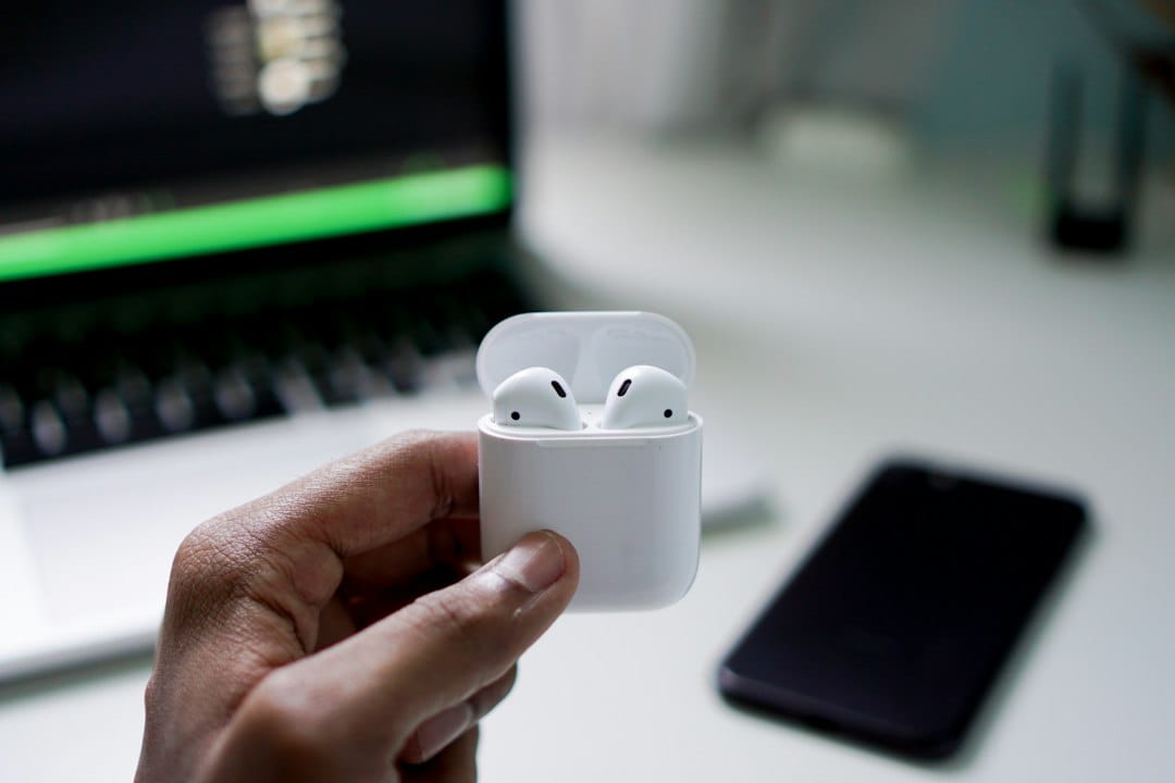Someone wearing AirPods‑style earbuds while enjoying music outdoors