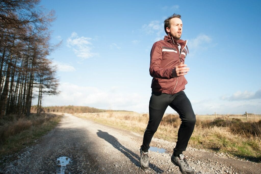Runner wearing sporty open‑ear earbuds with a translucent charging case
