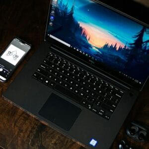 A professional using the Dell XPS 14 laptop in a modern coffee shop