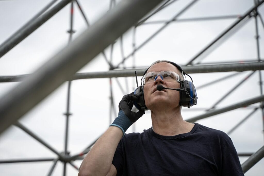 A worker wearing safety goggles and hearing protection earmuffs