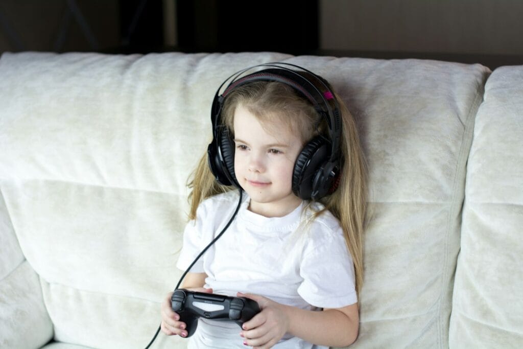 Young girl wearing headphones on a couch