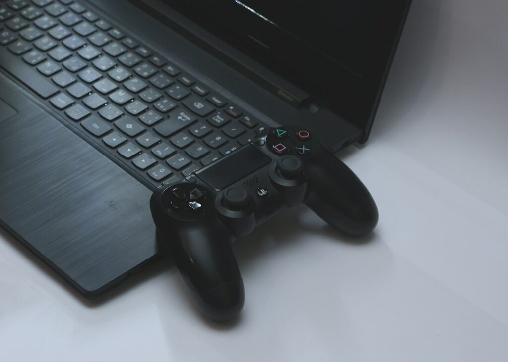 Game controller resting on a black gaming laptop