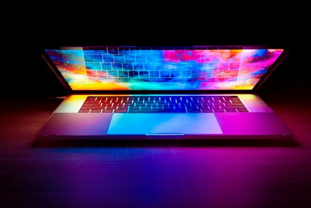 Laptop screen glowing with vivid colors in a dark room