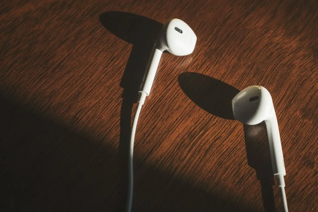 White wireless earbuds on a wooden table