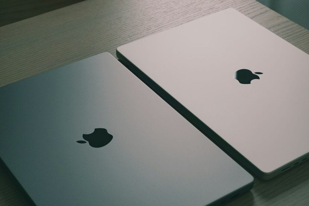 Two Apple laptops side by side on a table